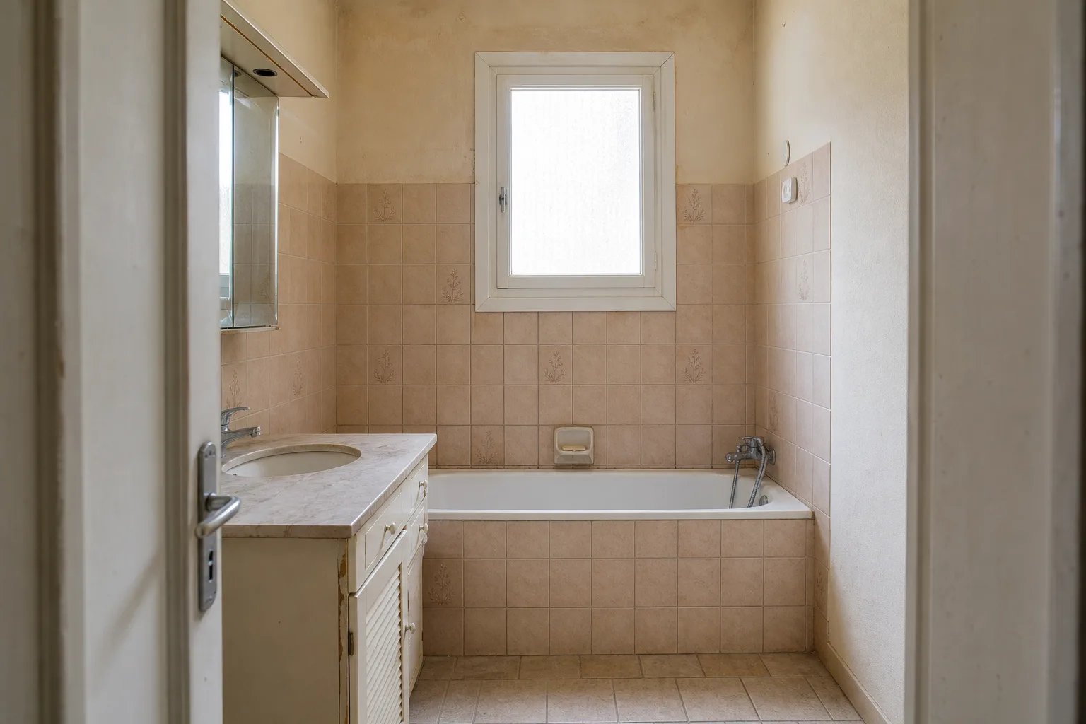 Salle de bain datée avant rénovation, vue depuis la porte
